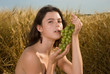 Beautiful slavonic girl on picnic in wheat field with grapes