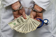 Doctor with dollar bank notes and handcuffs