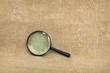 Old magnifier on brown canvas background Old magnifier on brown canvas background