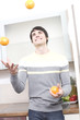 Foto: junger mann jongliert mit orangen junger mann jongliert mit orangen
