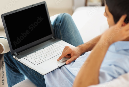 Photo: Closeup of a guy working on a laptop indoor Closeup of a guy working on a laptop indoor