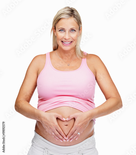 Woman holding hands in heart shape over pregnant belly