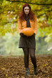 A young woman holding a pumpkin
