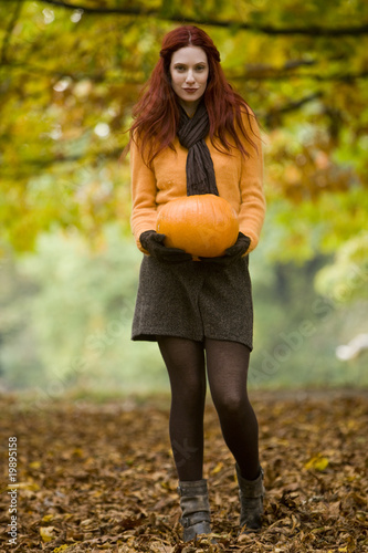 Photo: A young woman holding a pumpkin A young woman holding a pumpkin