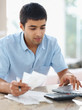 Young man paying bills using laptop at home