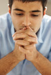 Closeup of a young man praying to god with hope