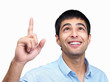 Happy young guy pointing upwards against white background