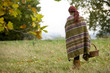 A young woman wrapped in a blanket, holding a wicker basket