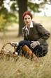 A young woman in a field holding a wicker basket