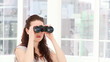 Serious businesswoman looking through binoculars
