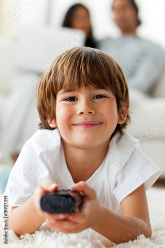 Adorable little boy watching TV lying on the floor Adorable little boy watching TV lying on the floor