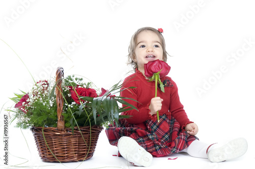 Photo: Cute little girl playing with a basket of red roses Cute little girl playing with a basket of red roses