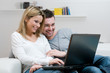 Smiling young couple with laptop