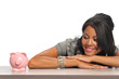 Woman looking at a piggy bank Woman looking at a piggy bank