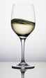 A glass cup of sloshing white wine