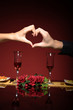 couple at restaurant table making a heart with theyr hands couple at restaurant table making a heart with theyr hands