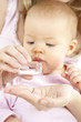junge mama gibt ihrem baby globuli