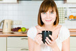 Young successful woman, enjoying a cup of coffee in her home.