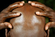 rear view of afro man with hands holding his head