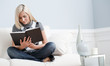 Woman Sitting on Couch and Reading a Book