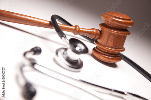 Photo: Gavel and Stethoscope on Gradated Background Gavel and Stethoscope on Gradated Background