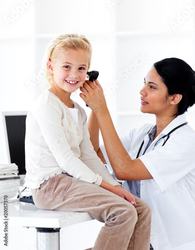 Photo: Concentrated female doctor checking her patient's ears Concentrated female doctor checking her patient's ears