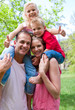 Smiling parents giving their children piggy-back ride