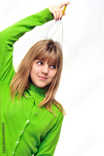 Photo: Teen girl using head scalp massage Teen girl using head scalp massage