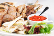 Assorted meat grilled with pita, herbs and spicy sauce