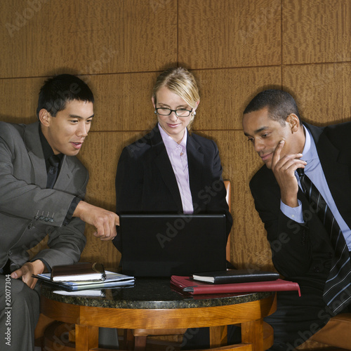 Photo: Businesspeople Looking at Laptop Businesspeople Looking at Laptop