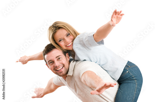 Photo: Happy smiling couple piggyback arms outstretched Happy smiling couple piggyback arms outstretched