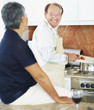 Smiling senior man preparing food for wife