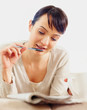 Cute woman solving a crossword in the newspaper