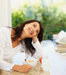 Smiling young woman with breakfast placed in front of her
