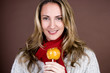 A mid adult woman holding a toffee apple, smiling