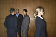 Businesswoman Walking by Businessmen