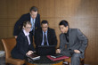 Businesspeople Gathered Around a Laptop