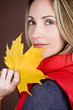 A mid adult woman holding an autumn leaf