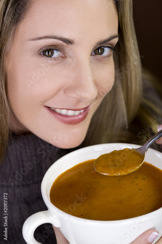 Photo: A mid adult woman eating soup A mid adult woman eating soup