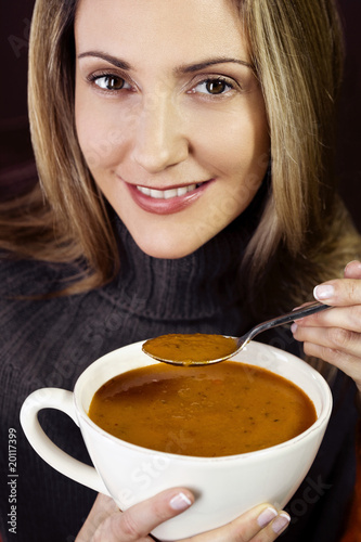 Photo: A mid adult woman eating soup A mid adult woman eating soup
