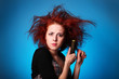 Girl with hair raiser in panic try to combing own hair