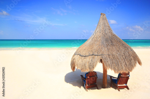 Photo: Grass hut and chairs on a gorgeous beach resort Grass hut and chairs on a gorgeous beach resort
