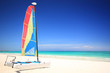A colorful catamaran sailboat on a gorgeous tropical beach
