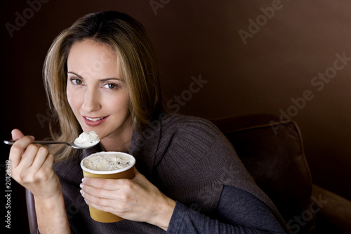 Photo: A mid adult woman eating ice cream A mid adult woman eating ice cream
