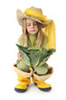Jeune fille , bottes jaune, un choux vert et un chapeau de paill