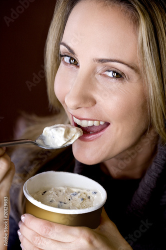 Photo: A mid adult woman eating ice cream A mid adult woman eating ice cream