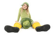 Enfant  assise avec des bottes jaune et un choux sur la tête