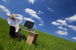 Man Relaxing At Office Desk & Computer In a Green Field