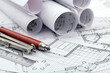 rolls of architectural blueprints, ruler, pencil, compass rolls of architectural blueprints, ruler, pencil, compass