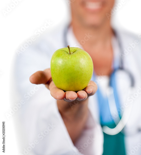 Photo: Close-up of a doctor presenting a green apple Close-up of a doctor presenting a green apple